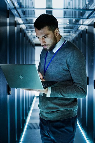 Homem com computador no datacenter