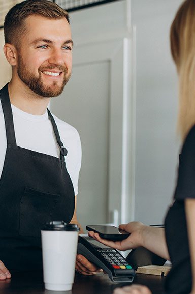 Vendedor sorrindo para o cliente no ponto de venda