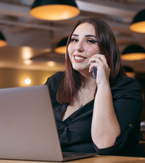 mulher trabalhando com notebook e atendendo o celular