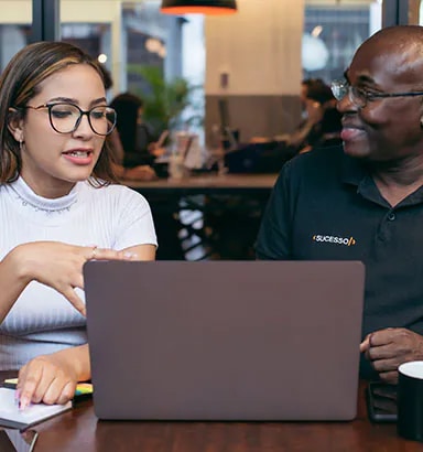 Colaboradores conversando em frente ao notebook